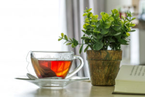 close-up-the-warm-black-tea-cup-on-the-wooden-table_25381-369-300x200