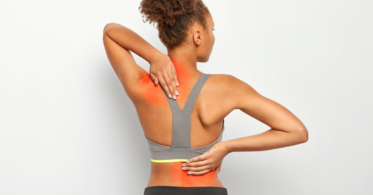 faceless-curly-woman-suffers-from-spine-pain-wears-sport-bra-shows-location-inflammation-isolated-white-background