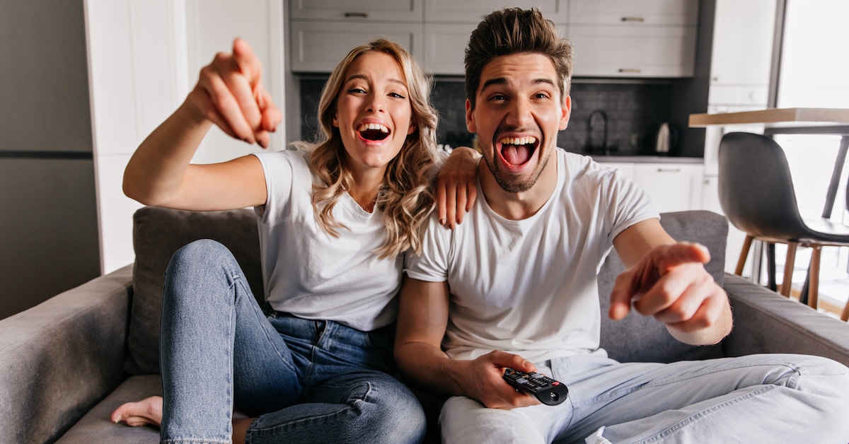 laughing-young-people-sitting-couch-smiling-family-watching-tv