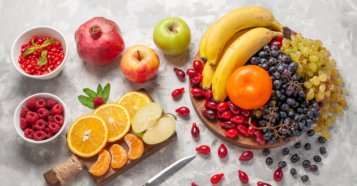 top-view-fresh-fruits-composition-bananas-dogwoods-grapes-light-white-surface-fruit-berry-freshness-vitamine