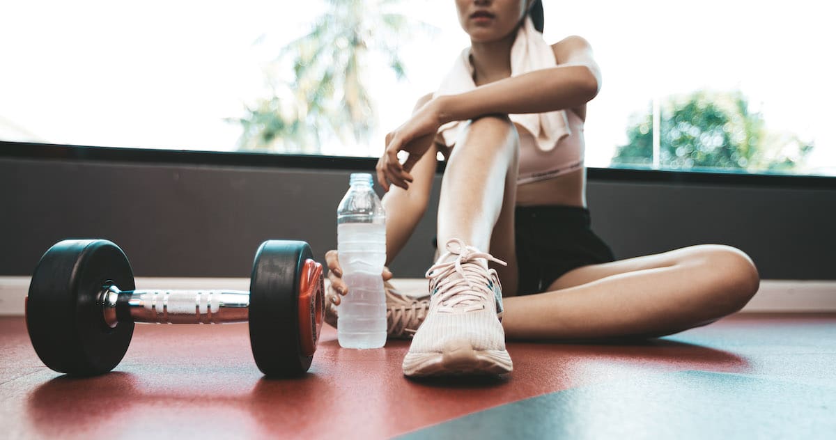 women-sit-back-relax-after-exercise-there-is-water-bottle-dumbbells