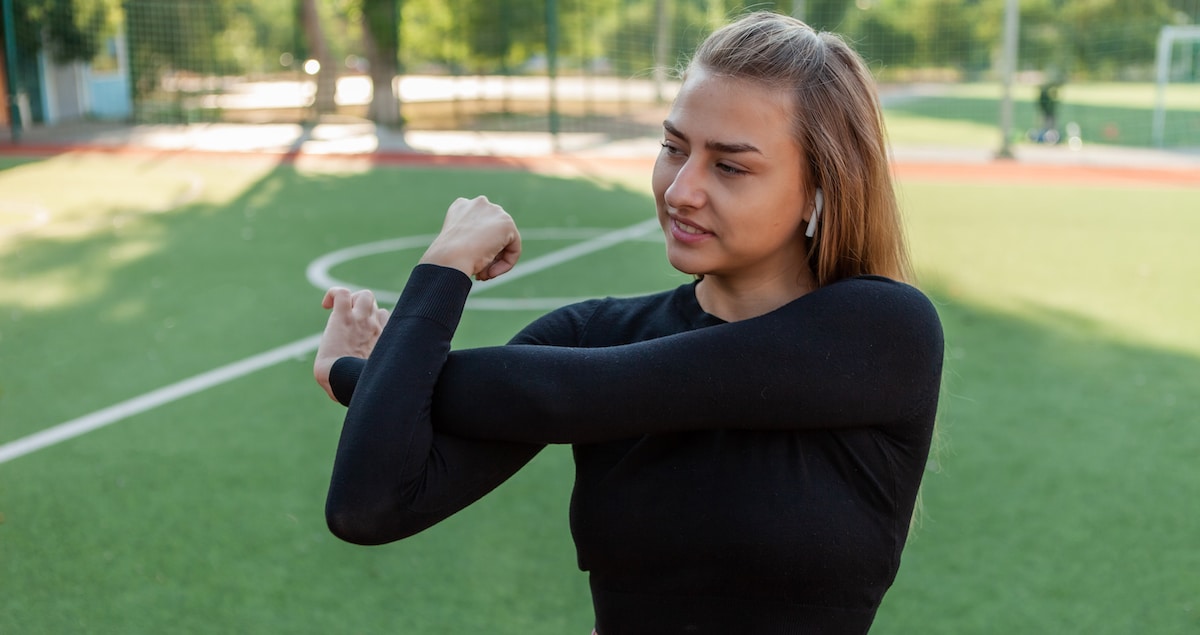 young-slim-fit-woman-sportswear-doing-pre-training-warm-up-hand-stretching-stadium-healthy-lifestyle-concept-outdoor-training